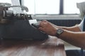 Man working on retro typewriter at desk in parlor room Royalty Free Stock Photo