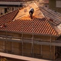 Man working on a roof and scaffolding for the renovation of the old building