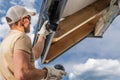 Construction Worker Installing Gutter Elements