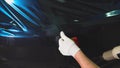 Man working at service station applied vinyl on the machine, using a carboxylic.