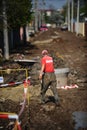 Man working on the sewer and water pipeline on an unpaved road in Bucharest