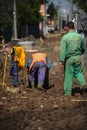 Man working on the sewer and water pipeline on an unpaved road in Bucharest