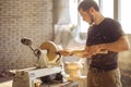 Man working at small wood lathe, an artisan carves piece of wood Royalty Free Stock Photo