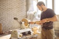 Man working at small wood lathe, an artisan carves piece of wood Royalty Free Stock Photo