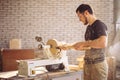 Man working at small wood lathe, an artisan carves piece of wood Royalty Free Stock Photo