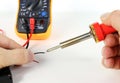 Man working with soldering iron and electronic measuring device Royalty Free Stock Photo
