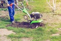 Man working in the spring garden with tiller machine