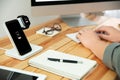 Man working at table while mobile phone and smartwatch charging with wireless device Royalty Free Stock Photo