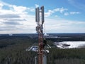 Man working on a telecommunications tower against the background of an evergreen forest. Royalty Free Stock Photo