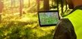 Man working with topographic map data on digital tablet in forest. copy space