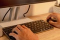 A man working using a computer. Close up shot of male hands on computer keyboard and mouse Royalty Free Stock Photo