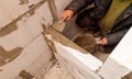 A man is working on a wall, using a trowel to apply cement Royalty Free Stock Photo