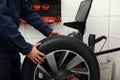 Man working with wheel balancing machine at service, closeup Royalty Free Stock Photo