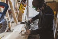 Man working with wood in workshop using sanding machine