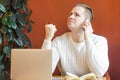 Man at workplace in office at computer, talking on phone, hears good news.