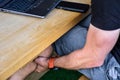 A man works on a computer and on a mobile phone. A man is sitting on a balcony on a wooden bench and on a wooable Royalty Free Stock Photo