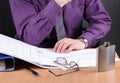 Man works with documents until late, flask with alcohol on the table