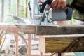 A man works with his hands and a construction tool. Electric saw. Work on wooden boards. To cut the materials. Royalty Free Stock Photo