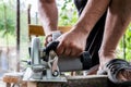 A man works with his hands and a construction tool. Electric saw. Work on wooden boards. To cut the materials. Royalty Free Stock Photo