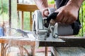 A man works with his hands and a construction tool. Electric saw. Work on wooden boards. To cut the materials. Royalty Free Stock Photo