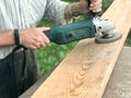 The man works with his hands, grinds the disk around for the grinder, the electric tool for grinding and polishing the surface Royalty Free Stock Photo