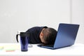 Man works in his office with a lot of stress having a headache with a migraine and suffering from tiredness and burnout Royalty Free Stock Photo