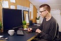 A man works at home with a tablet and pen. Griffin designer, a man looks at a green screen computer. A man works on freelance Royalty Free Stock Photo