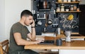Man works at a laptop in the interior of a home decor in the kitchen. Remote work