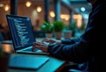 Man works late night on laptop in office. Coding on laptop screen. Focus on programming. Modern tech environment. Concentrated on