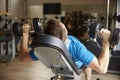 Man works out with dumbbells on a bench at a gym, back view Royalty Free Stock Photo