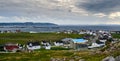 Man works on a roof on blustery day, Bonavista, Newfoundland.