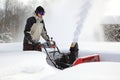 A man works snow blowing machine Royalty Free Stock Photo