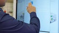 Man works on a touch screen. Young scientist uses a large touch screen to work