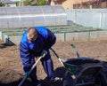 A man works in a vegetable garden in early spring