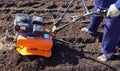 A man works in a vegetable garden in early spring. Digs the ground. Works as a cultivator, walk-behind tractor