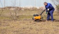 A man works in a vegetable garden in early spring. Digs the ground. Works as a cultivator, walk-behind tractor