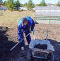 A man works in a vegetable garden in early spring