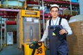 Man works in a warehouse with a forklift. Royalty Free Stock Photo