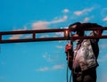 A man works with a welding machine and metal on the roof at dusk Royalty Free Stock Photo