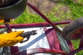 The man works by welding. A welder repairs an iron garden cart using electric welding
