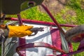 The man works by welding. A welder repairs an iron garden cart using electric welding