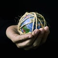 Man with a world globe tied with rope