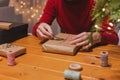 Man wrapping Christmas present at home with blurred lights on the background Royalty Free Stock Photo