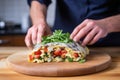 man wrapping a leftover slice of cauliflower pizza