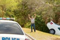 Man wrecked car into deep ditch waving down police officer car Royalty Free Stock Photo