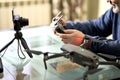 A man writes a blog in front of a camera about taking photos with a quadrocopter. He is holding the remote control from the drone. Royalty Free Stock Photo