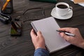 Man writes in a notebook on a wooden table Royalty Free Stock Photo