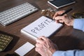 Man writes text Profit in notepad Royalty Free Stock Photo