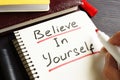 Man is writing Believe In Yourself in a note. Royalty Free Stock Photo