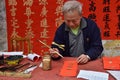 FOSHAN, CHINA - CIRCA JANUARY 2020: A man writing blessing antithetical couples during the Spring Festival. Royalty Free Stock Photo